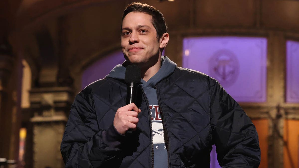Pete Davidson holding a mic on SNL