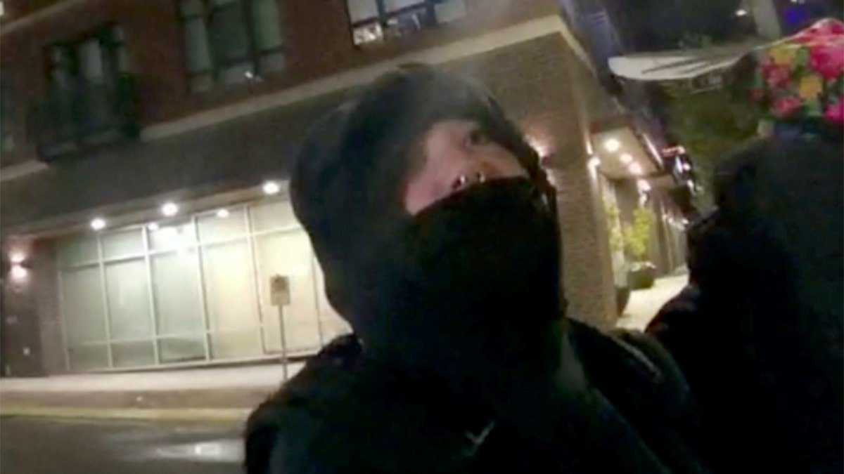 Person with hoodie and mask on face