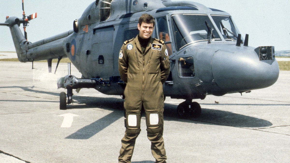 A young Prince Andrew standing in front of a helicopter.