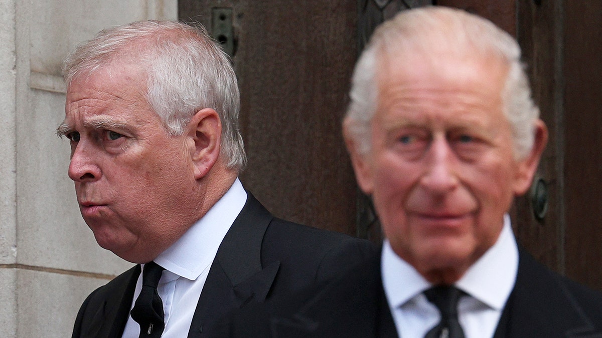 King Charles looks forward with his brother Andrew behind him, with his back turned.