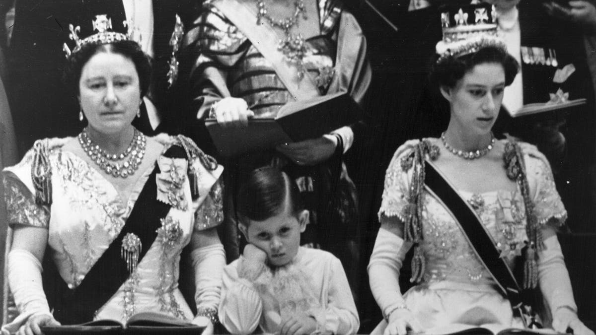 Prince Charles looking board as his grandmother and sister watch his mother's coronation intensely.