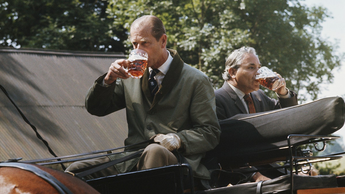 Prince Philip drinking a pint of beer.