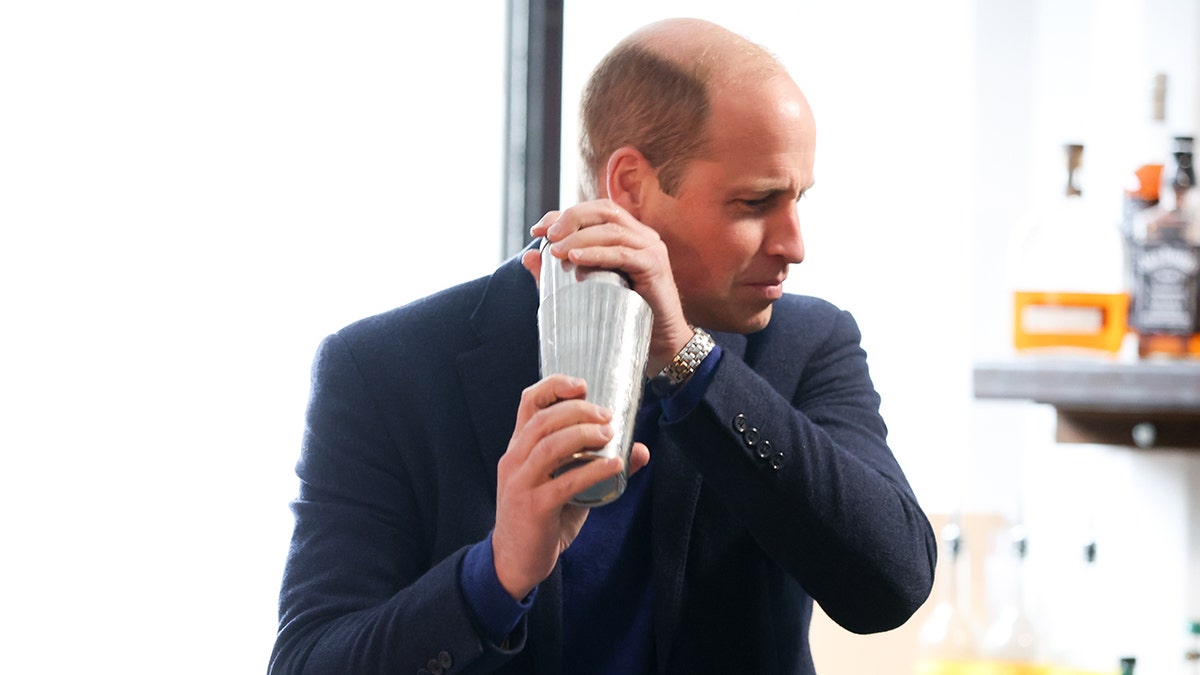 Prince William holding a cocktail shaker.