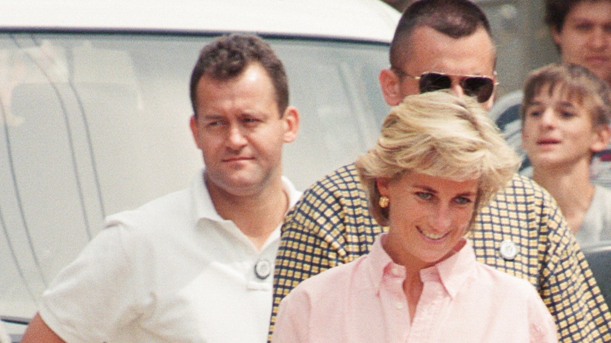 Paul Burrell walking behind a smiling Princess Diana.