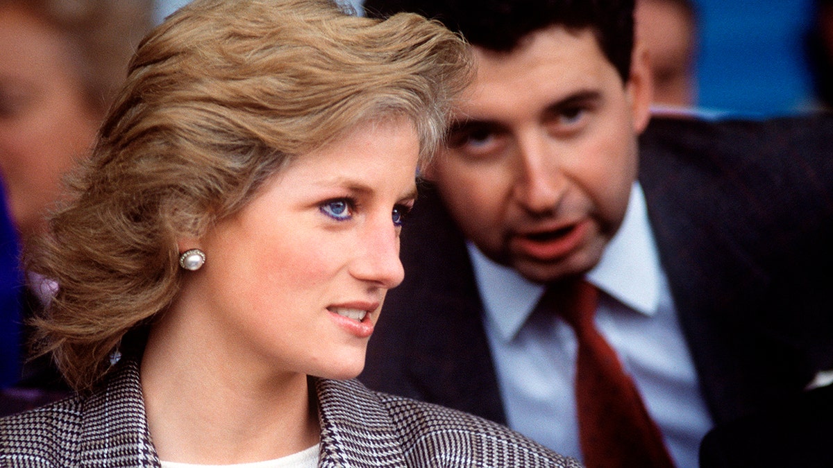 Patrick Jephson whispering something to an attentive Princess Diana.
