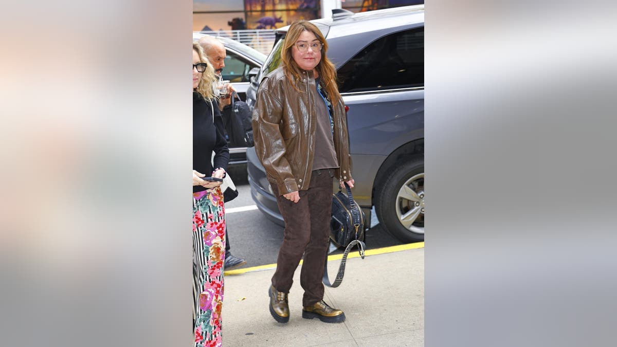 Rachael Ray in a brown leather jacket, brown pants and brown boots outside in New York City