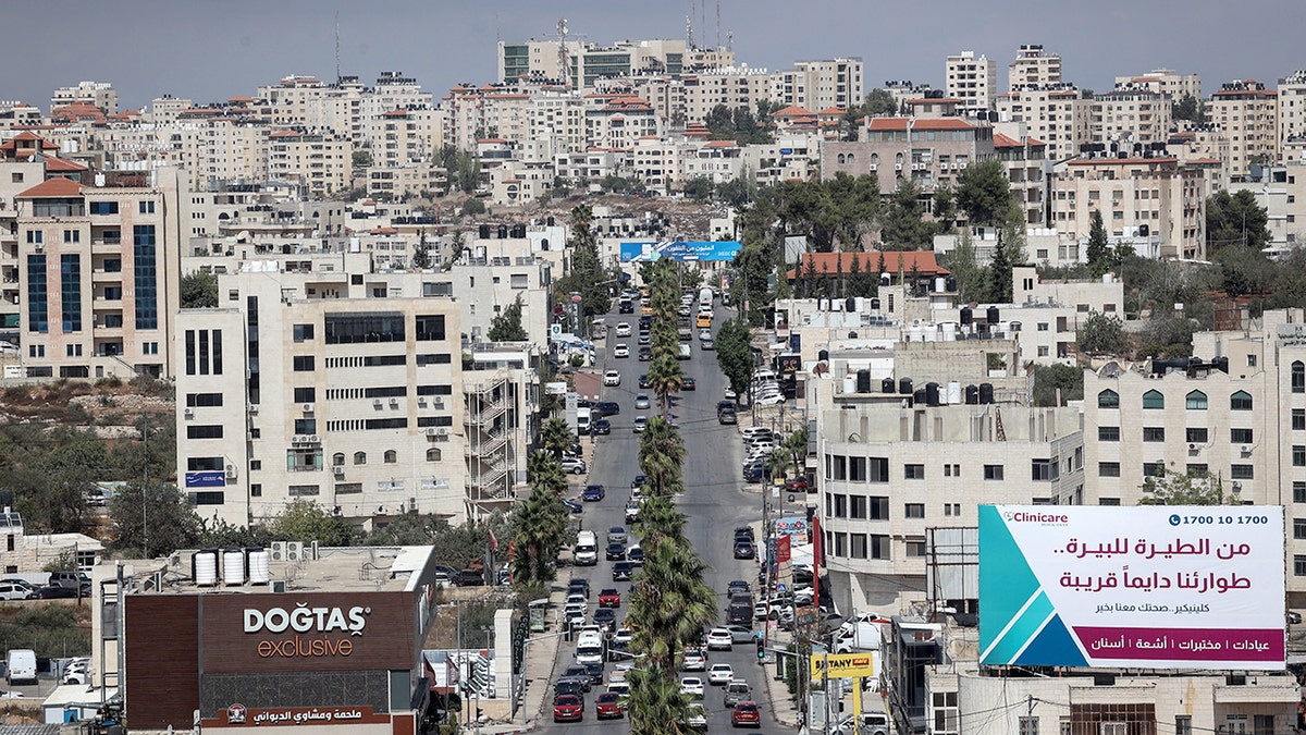 Cars and vehicles travel down street in Ramallah in the West Bank