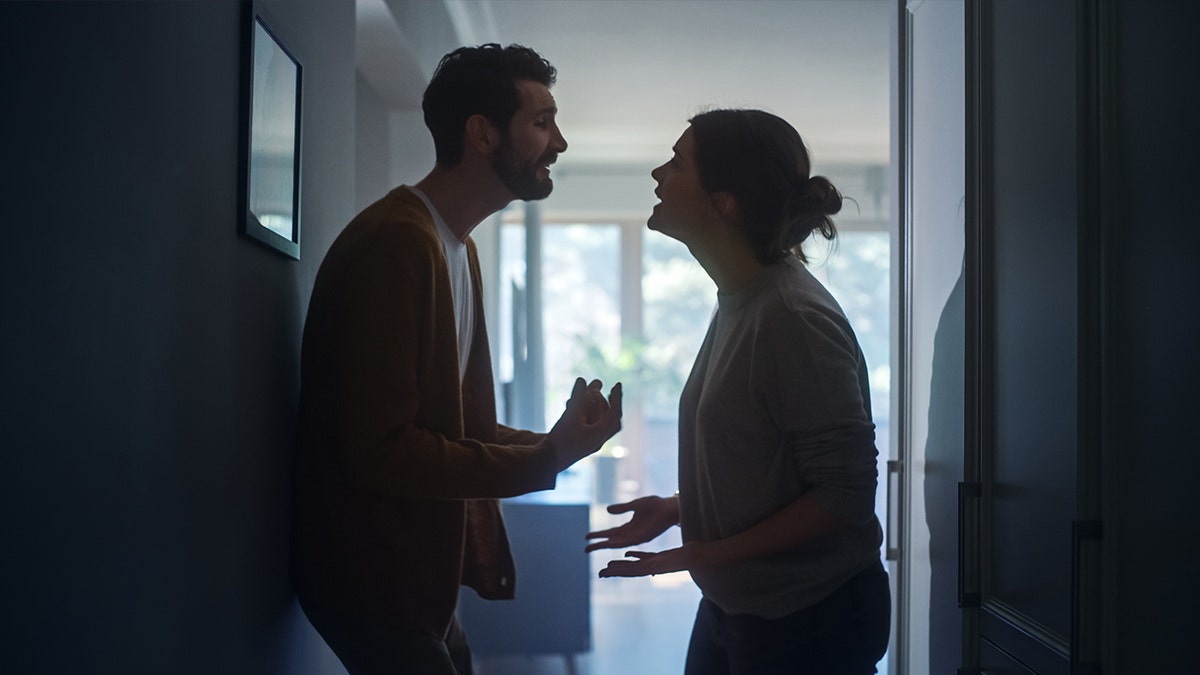 Couple arguing in doorway