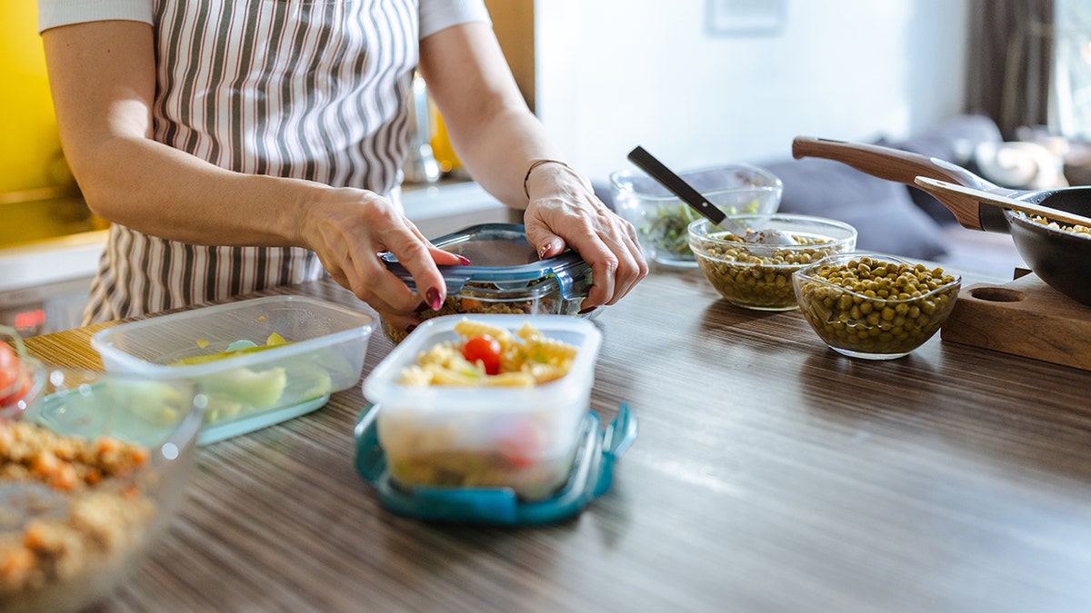 Woman packing meal containers in kitchen