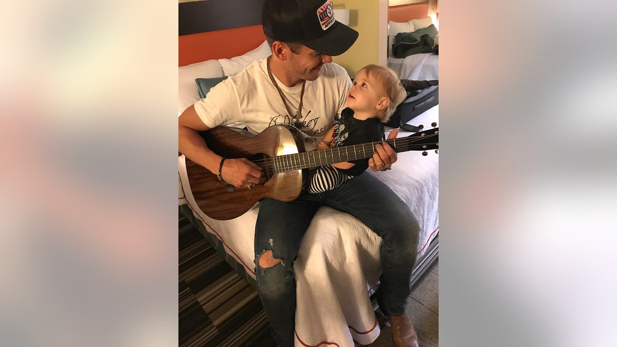 Granger Smith playing guitar for his son River.