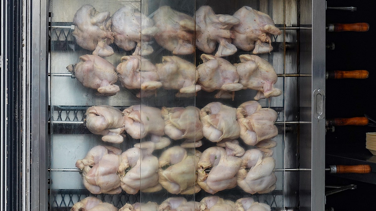 Raw chickens on a rotating spit