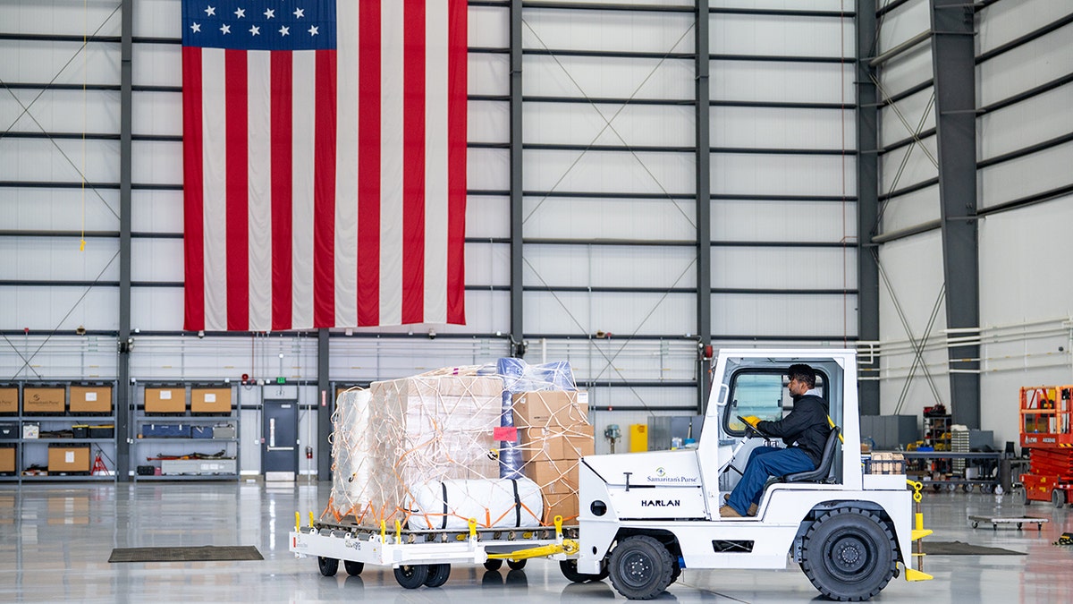 Worker tows relief supplies inside Samaritan’s Purse hangar.