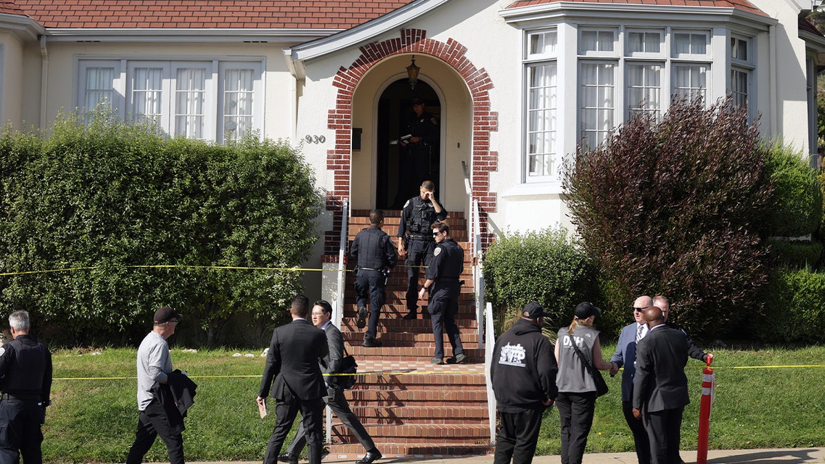 Law enforcement enter the home in San Francisco, Calif. where a family of four was found dead
