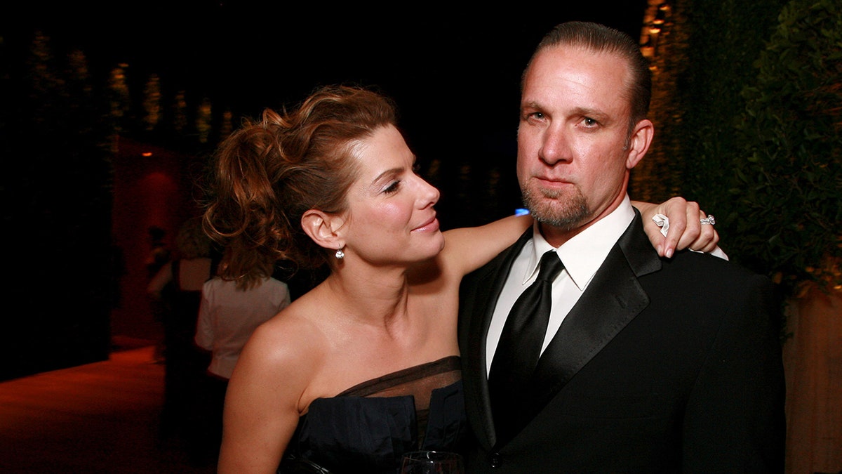 Sandra Bullock wraps her arm around then-husband Jesse James at a Vanity Fair event.