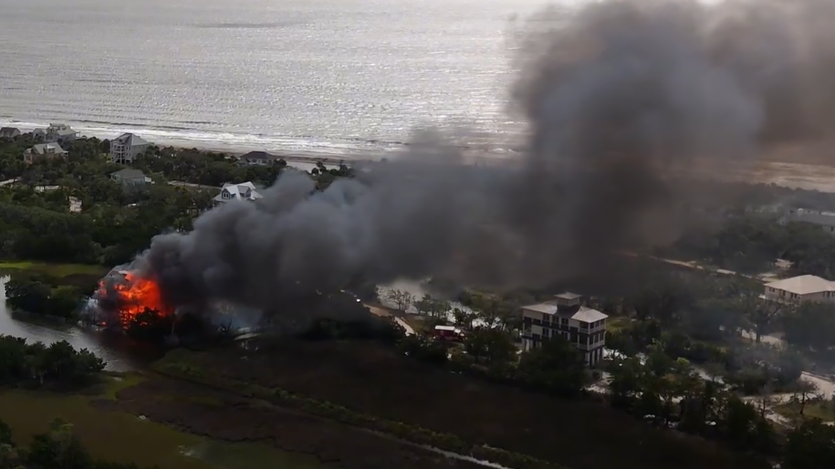 Smoke billowing from a waterfront home