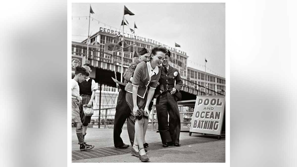 A woman trying to pull down her skirt in Coney Island.