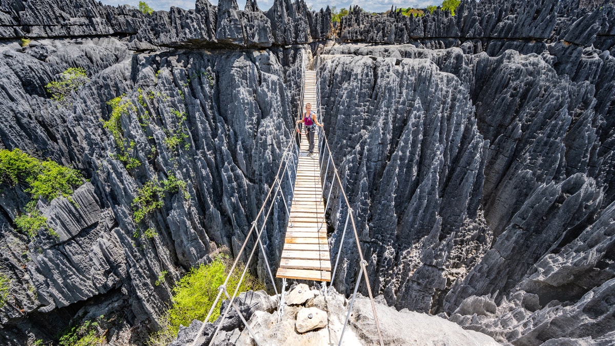 Woman alone hiking on bridge in Madagascar