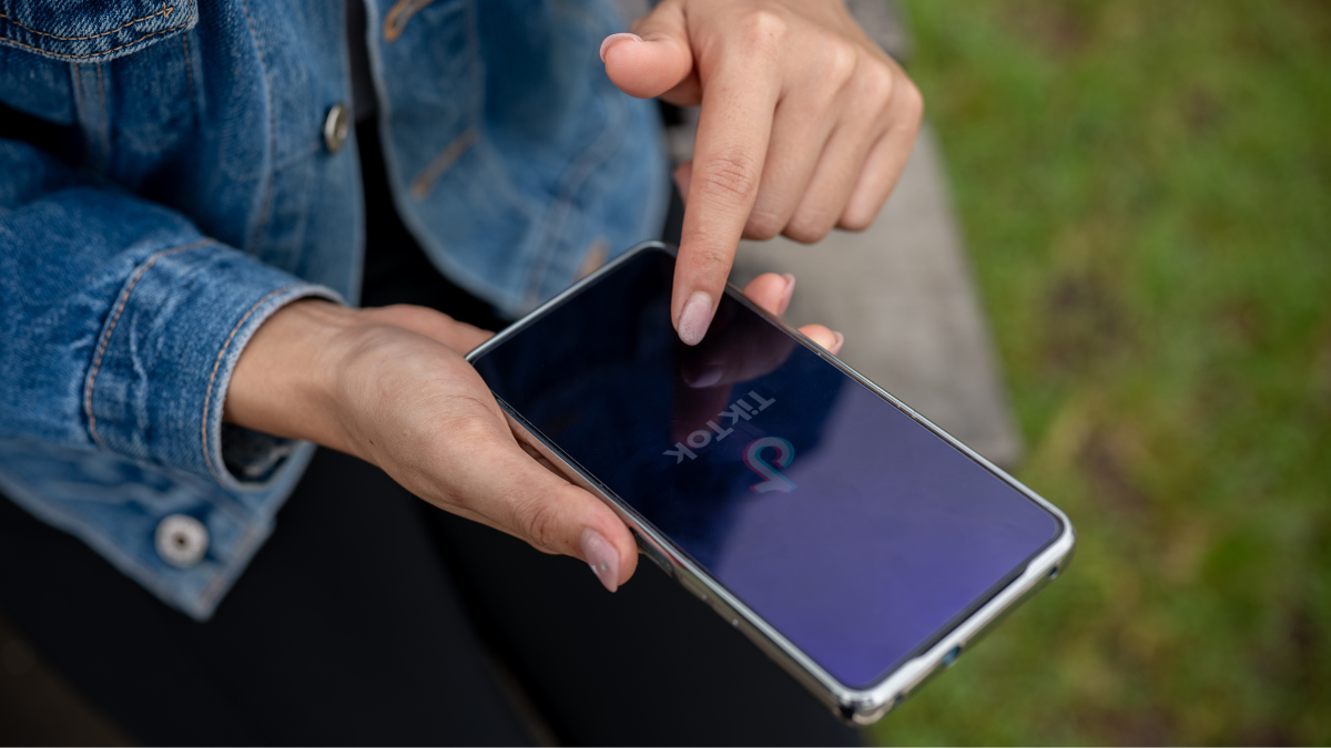 a woman's hand scrolling on tiktok on her phone