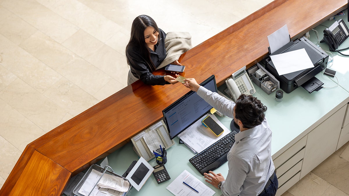Woman traveling and logging in at desk.