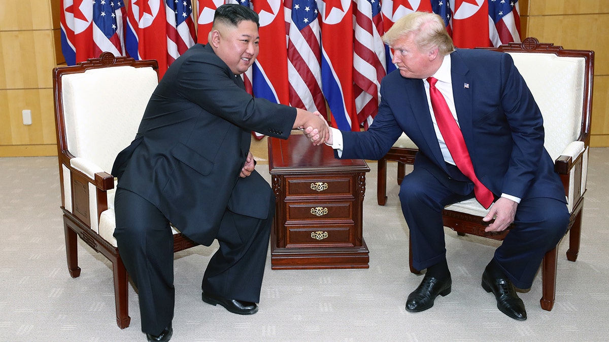 Pemimpin Korea Utara Kim Jong Un berjabat tangan dengan Presiden AS Donald Trump