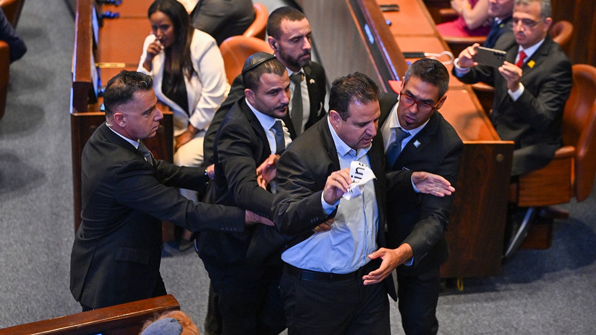 The Knoset member is removed from the room after holding a protest of protesting during the US President Donald Trump's address in Knowset.