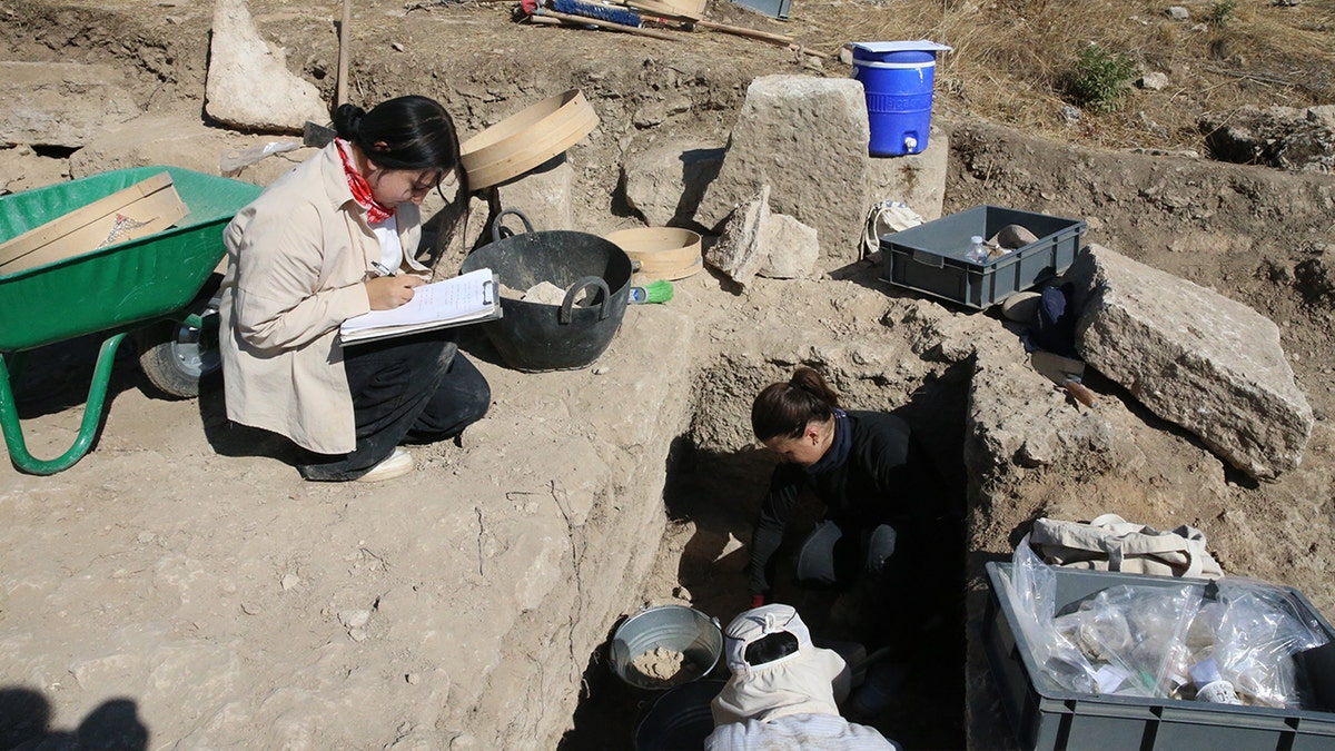 Archaeologists uncover 2,200-year-old ancient tombs in Colossae, Turkey 3 Archaeologists huddled together near grave