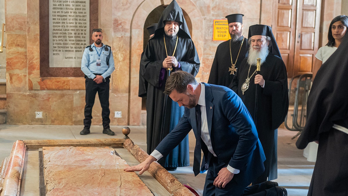 El vicepresidente JD Vance coloca la mano sobre un objeto durante un recorrido por una iglesia en Jerusalén