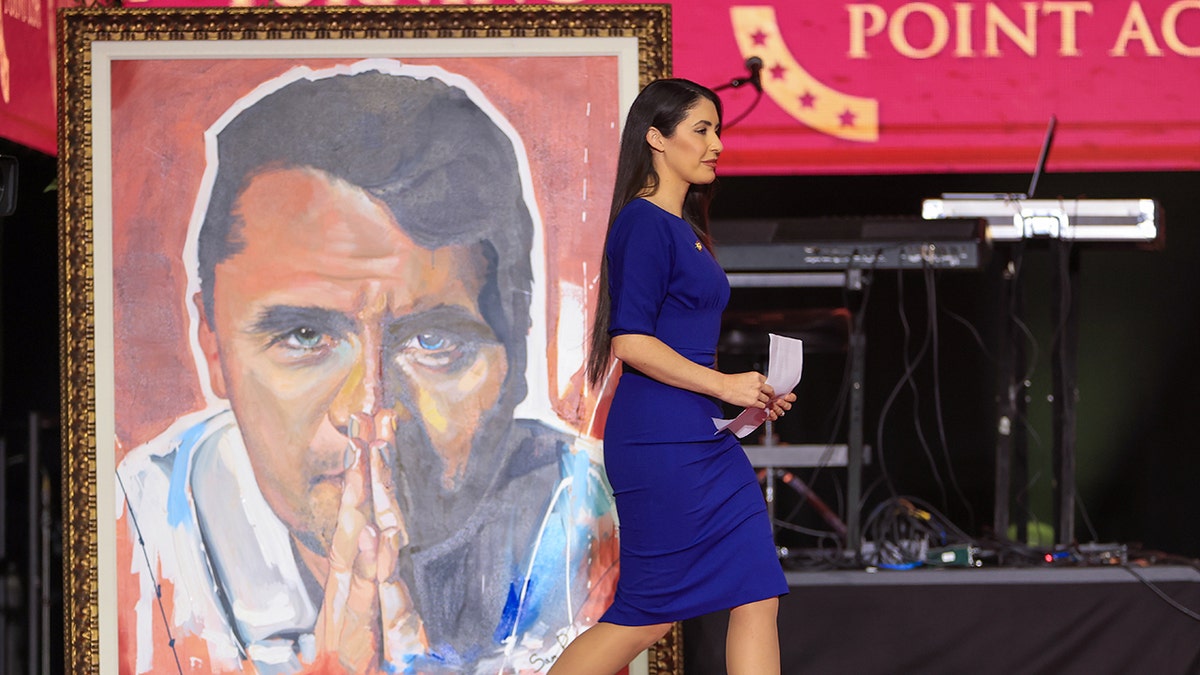 Anna Paulina Luna walking past Charlie portrait
