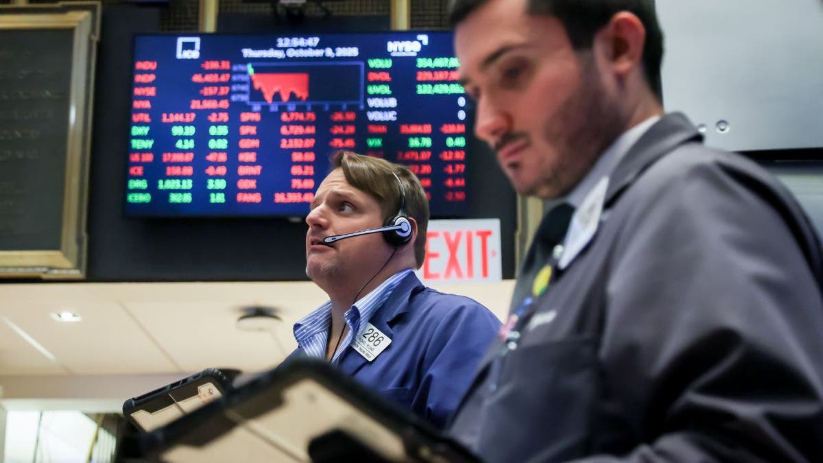 Traders na Bolsa de Valores de Nova York à medida que as ações sobem após o relatório de inflação de setembro.