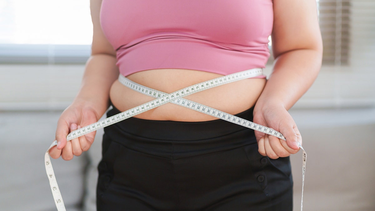 woman measuring her waist