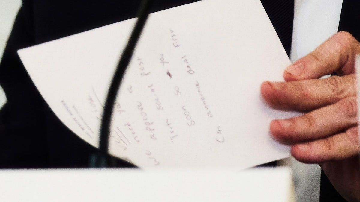 Secretary of State Marco Rubio writes a note before handing it to President Donald Trump during a roundtable meeting on antifa in the State Dining Room at the White House, Wednesday, Oct. 8, 2025, in Washington.
