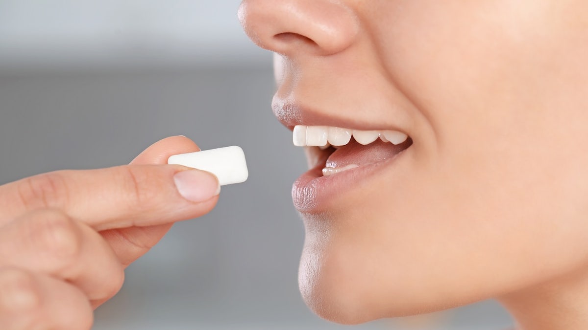 Woman putting gum in mouth