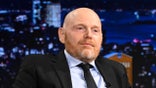 Bill Burr is seated on stage during an Episode of The Tonight Show starring Jimmy Fallon