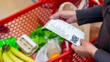 Close up of unrecognizable customer checking her receipt after purchasing groceries in the supermarket