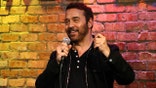 Jeremy Piven in a black shirt doing stand-up at the Improv.