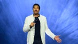 Lionel Richie performing live on stage at Accor Arena with blue background and lights.