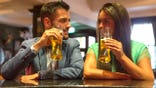 A man and woman share a drink at a bar