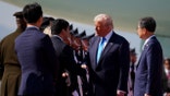 President Donald Trump greets officials as he arrives at Gimhae International Airport