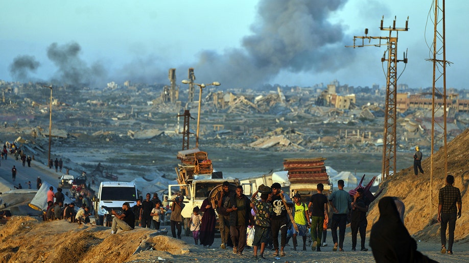 Displaced Palestinians walk in Gaza Strip