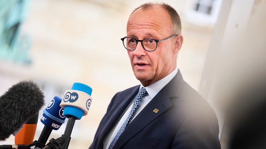 German Chancellor Merz standing at microphone