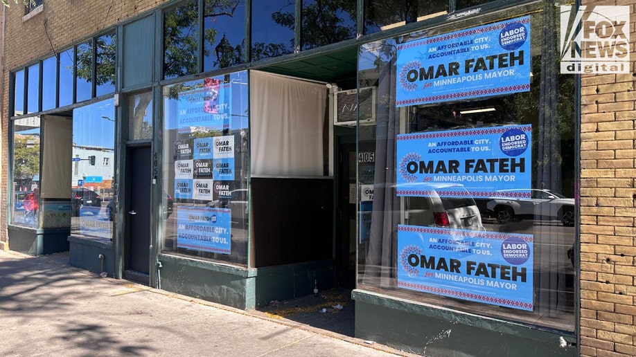 Storefront windows covered with Omar Fateh for mayor signs