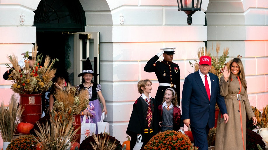 President Donald Trump and First Lady Melania Trump welcome guests to the White House Halloween celebration