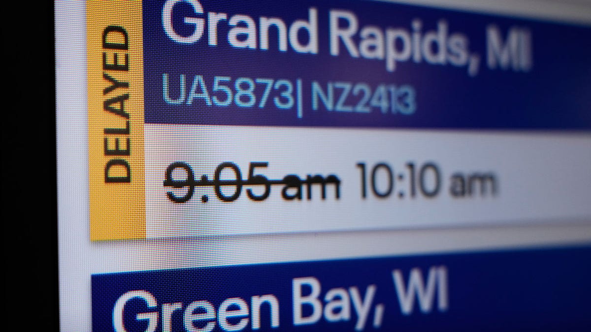 Uma tela no aeroporto mostrando atrasos nos voos.