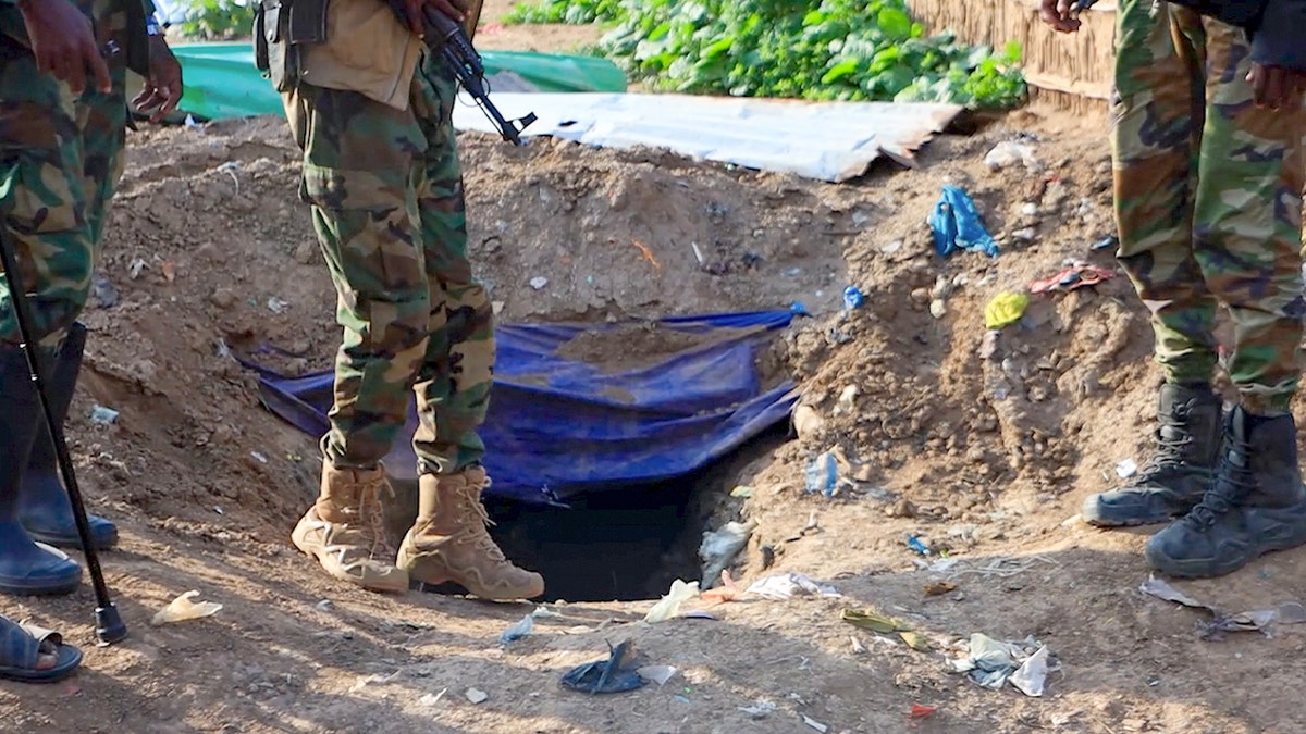 Soldiers' feet shown next to a hole that is allegedly a terror group's hideout