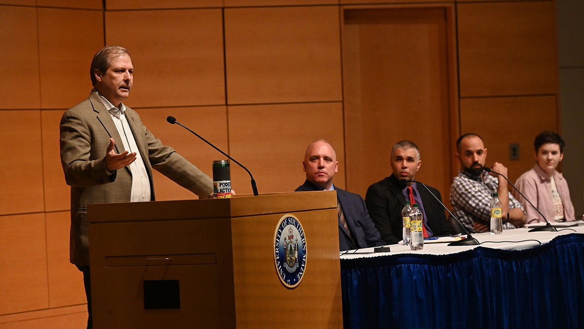 Alex Vitale gives lecture from behind wooden lectern