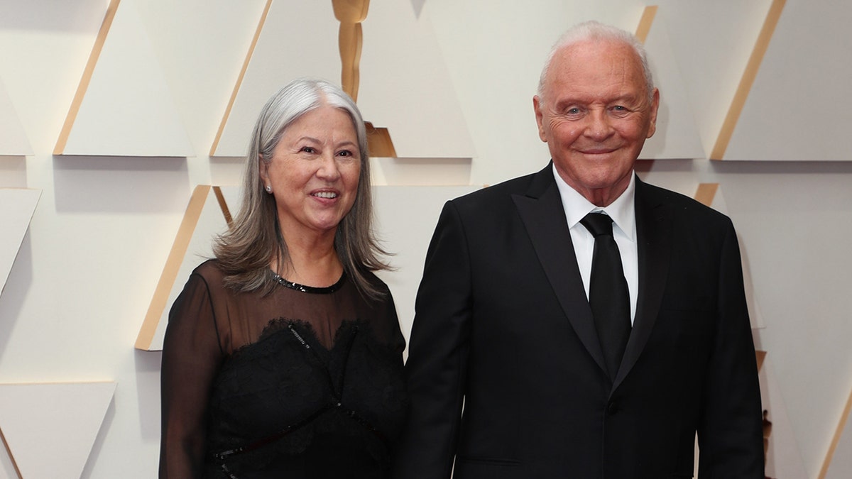 Anthony Hopkins wears black suit and tie with wife Stella.