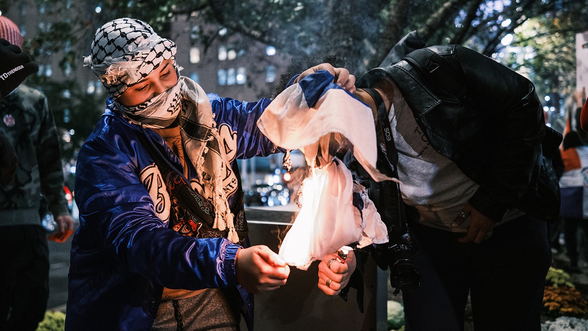 Burning Israeli flag at antisemitic protest in New York.
