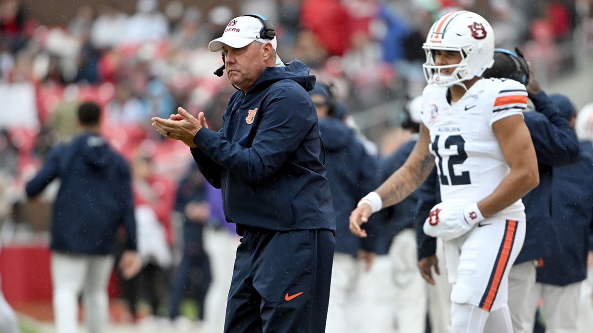 Hugh Freeze claps on the sideline