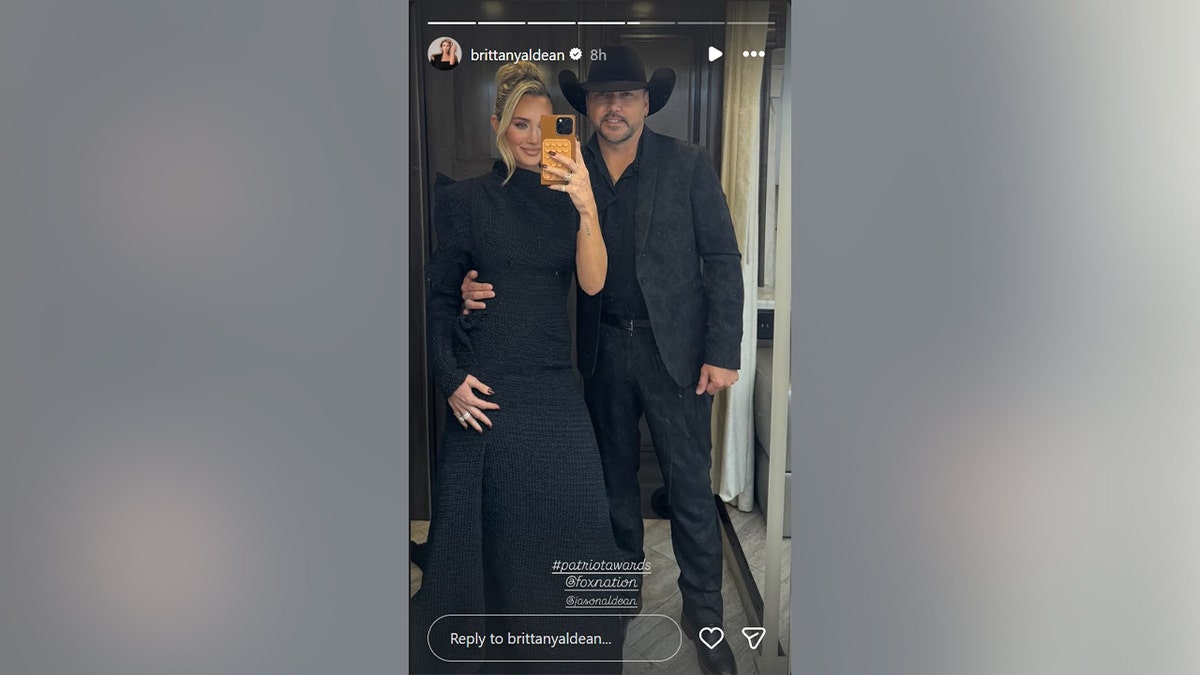 A mirror selfie of Jason Aldean and Brittany Aldean in black outfits.