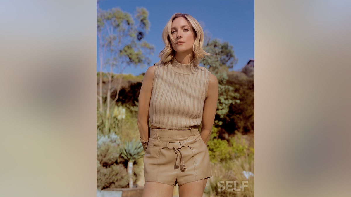 Brittany Snow in a tan outfit in a field of flowers for Self Magazine